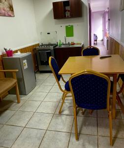 kuchnia z drewnianym stołem i krzesłami w obiekcie Departamentos k&m w mieście Puerto Natales