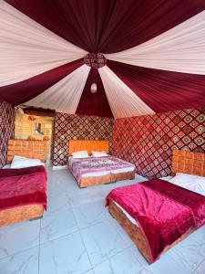 a large room with two beds and a tent at Wadi rum Golden land camp in Wadi Rum
