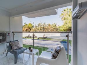 a living room with a large window with a view of a pool at Rio Gardens Aparthotel in Ayia Napa