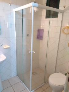y baño con ducha de cristal y aseo. en Pousada Girassois Hostel en Florianópolis