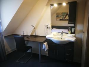 a bathroom with a sink and a mirror at Hotel Romäus in Villingen-Schwenningen