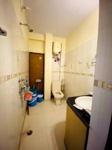 małą łazienkę z toaletą i umywalką w obiekcie The Wooden Lodge w mieście Nainital