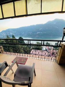 a balcony with a chair and a view of the water at The Wooden Lodge in Nainital