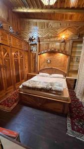 una camera da letto con letto in una camera in legno di The Wooden Lodge a Nainital