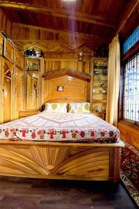 a bedroom with a bed in a wooden room at The Wooden Lodge in Nainital
