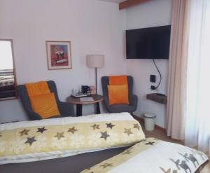 a hotel room with two beds and a tv at Garni Schwarzenstein in Campo Tures