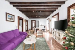 Una sala de estar con un sofá morado y un árbol de Navidad. en Lightbooking Panchita Villa de Mazo Piscina, en Mazo