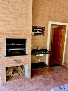a brick wall with a fireplace and a sink at Encanto Chalé in Monte Verde +98 photos