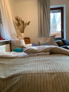 un grande letto con cuscini bianchi in una camera da letto di Zwei Zimmer Natur und Luxus Ferienwohnung mit Garten a Schmilau