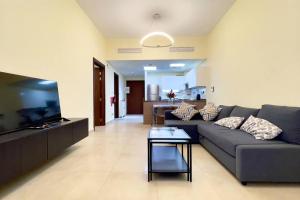 a living room with a couch and a tv at Azizi Luxurious 1 Bed Room apartment, Near Metro, Fully Furnished in Dubai