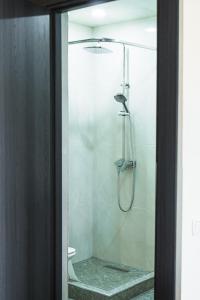 ducha con puerta de cristal y aseo en Garni Nature Villa en Garni