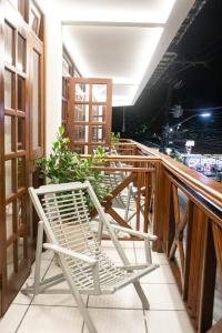 una silla blanca sentada en un balcón en Pousada Farol dos Borbas, en Abraão