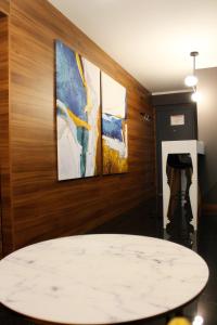a table in a room with three paintings on the wall at Elite Space in Niš