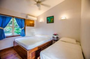 a bedroom with two beds and a window at Pirate's den Den Hotel in Sandy Bay