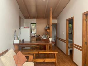 a kitchen with a table and a refrigerator at Cabañas Bungalows Costa Pichidangui in Pichidangui