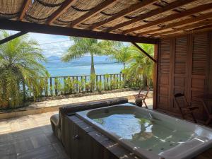 a bath tub in a room with a view of the ocean at Deck da Villa Picinguaba in Ubatuba