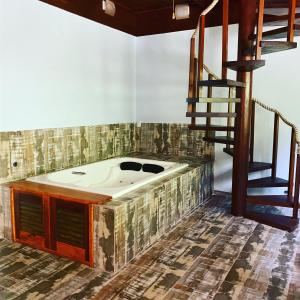 a jacuzzi tub in a room with a staircase at Deck da Villa Picinguaba in Ubatuba