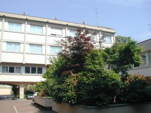 a bush in front of a large building at Augustus Hotel in Biella