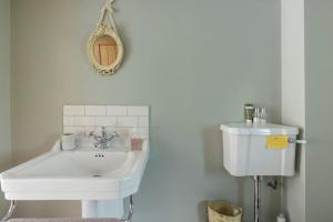 a bathroom with a white sink and a toilet at Luxury Apartment, The Barn, Cookham in Cookham