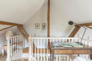 Una habitación con una mesa con una lámpara y una escalera en Luxury Apartment, The Barn, Cookham, en Cookham