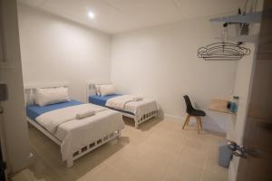 um quarto com duas camas e uma cadeira em Bangkok Cozy Home @Khaosan Road em Banguecoque