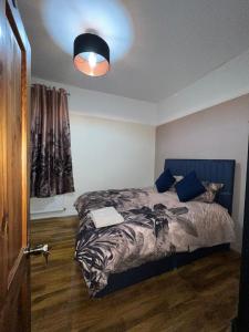 a bedroom with a bed with a blue headboard at 3 Bedroom Apartment in London