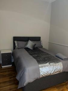 a large bed in a bedroom with a night stand at 3 Bedroom Apartment in London