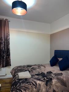 a bedroom with a bed and a blue lamp at 3 Bedroom Apartment in London