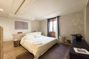 una camera da letto con un grande letto con lenzuola bianche di Rustic Style Apartments & Studios BCN a Barcellona