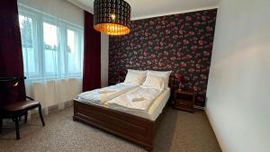 1 dormitorio con cama y lámpara de araña en Center House, en Dunaújváros