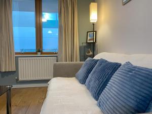 uma sala de estar com um sofá com duas almofadas azuis em May Disc - Long Stay - Contractors em Bristol