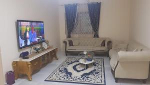 a living room with a couch and a tv at لايجار ٢ غرفه وصاله باقاسميه الشارقه in Sharjah
