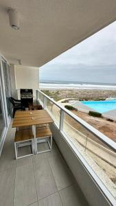 a balcony with a table and a view of the beach at Dpto en Resort Laguna del Mar frente al mar 2D2B in La Serena