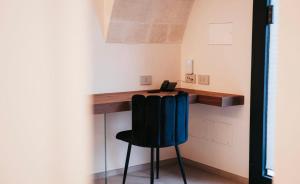 een kamer met een bureau met een stoel en een telefoon bij MASSERIA ACQUASALE - RELAIS & RESTAURANT in San Giorgio Ionico