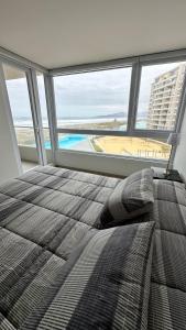 a bedroom with a bed and a view of the beach at Dpto en Resort Laguna del Mar frente al mar 2D2B in La Serena