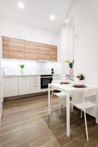 uma cozinha branca com uma mesa e cadeiras brancas em Luxurious Danubeside Apartment for 4 em Budapeste