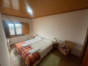 a bedroom with a bed and a window and a chair at Casa Rural Peñas II in Saucelle