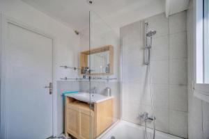 La salle de bains blanche est pourvue d'une douche et d'un lavabo. dans l'établissement Le Verdi, à Cannes
