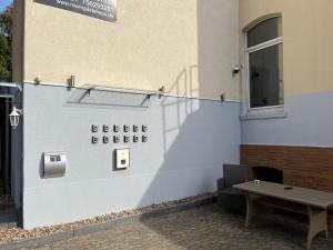 un panneau sur le côté d'un bâtiment avec un banc dans l'établissement Zimmer-Hotel-Pension, à Meine