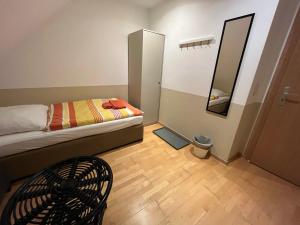 Cette petite chambre comprend un lit et un miroir. dans l'établissement Zimmer-Hotel-Pension, à Meine
