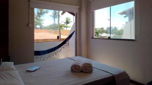 a bedroom with a bed with two towels on it at FAROL BEACH Apartamentos & Suítes in Salvador