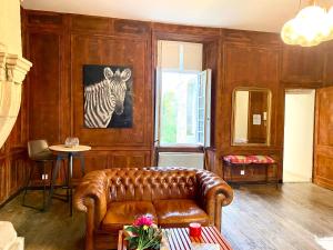a living room with a leather couch and a zebra picture at Loft Berberis, château XVe, Dinan in Taden