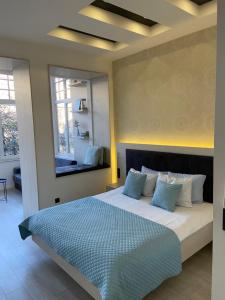 a bedroom with a large bed with blue pillows at Boulevard Apartments in Sarajevo