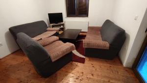 a living room with two couches and a table at Vila Ružica in Kupres