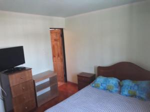 Hostal vivar في كالاما: غرفة نوم بسرير وتلفزيون بشاشة مسطحة