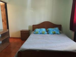 łóżko z niebieskimi poduszkami w pokoju w obiekcie Hostal vivar w mieście Calama
