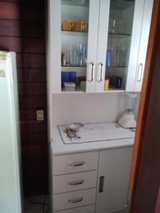 ゴヴェルナドール・セウソ・ラーモスにあるVenha ser felizの白いキャビネットとカウンタートップを備えたキッチン