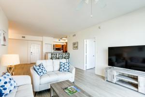 a living room with white furniture and a flat screen tv at Lantana Condo with Smart TV 11 Mi to Palm Beach! in Lantana