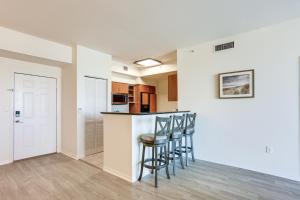 Una cocina con taburetes en una barra en un apartamento. en Lantana Condo with Balcony 11 Mi to Palm Beach!, en Lantana
