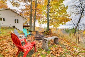 a group of chairs and a fire pit in a yard at Pet-Friendly Michigan Home with Deck and Views! in Harbor Springs